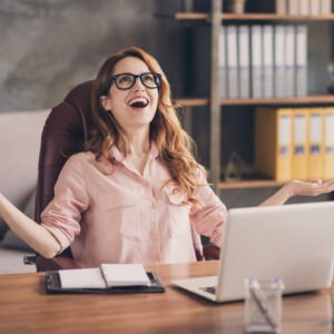 Les astuces pour réussir le TOEIC Close up photo beautiful she her business lady hand arm head raised up laugh laughter big salary income earnings genius startup notebook table sit office chair wearing specs formal-wear shirt